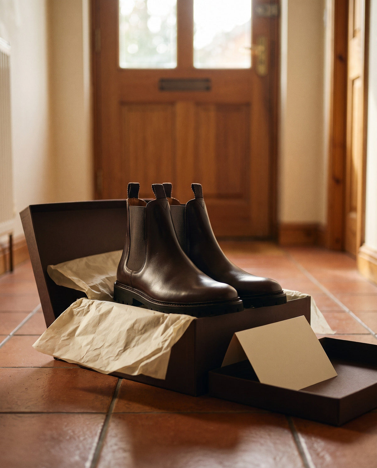 A pair of John White boots in their box on a hallway floor
